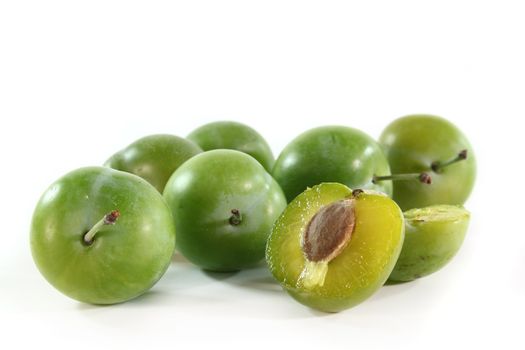 fresh green plums on a white background