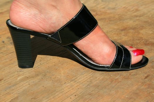 Woman's foot in a black leather shoe.
