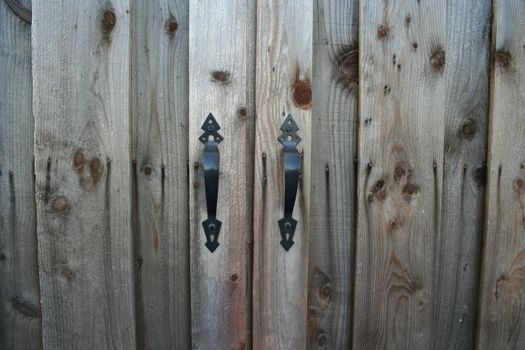 Close up of door knobs on a wooden door.
