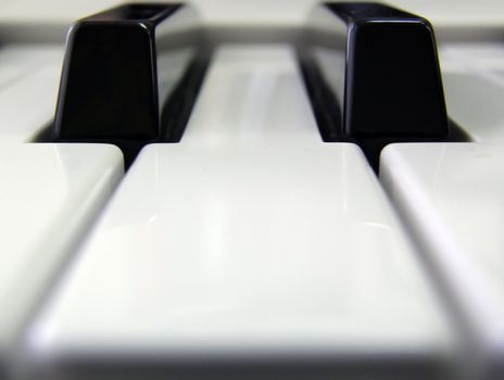 The white and black keys of the piano which have been defocused away along the edges 