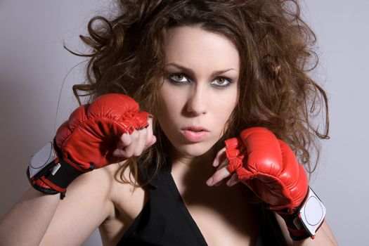 Beautiful woman with wild hair and boxing gloves
