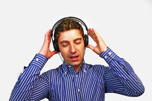 One guy singing while holding his headset with his hands, eyes closed