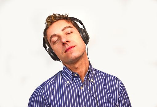 A good looking guy listening to music with headphones, eyes closed
