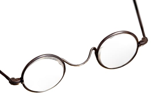 Old fashioned round reading glasses laying on a a white background and isolated