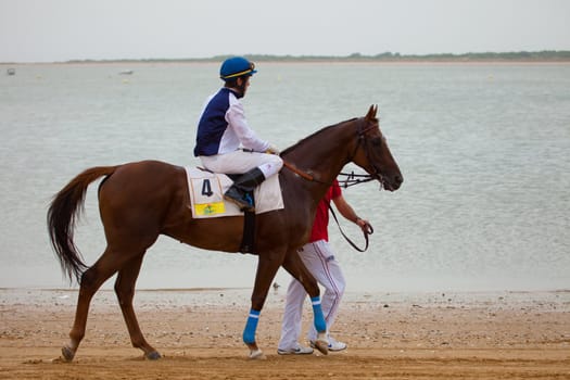 SANLUCAR DE BARRAMEDA, CADIZ, SPAIN - AUGUST 07: Unknown rider at the start of the horses races of the beach of Sanlucar de Barrameda on August 07, 2010 in Sanlucar de Barrameda, Cadiz, Spain.