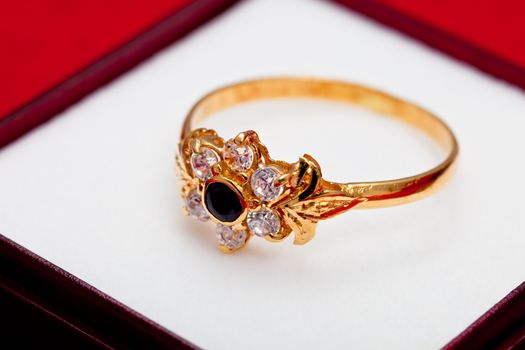 Fantastic gold ring adorned with one blue  and several white zirconia