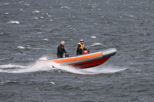 Speedboat powering across the water, flying over the waves.