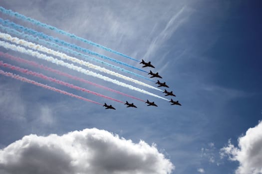 Red Arrows flying past a cloud
