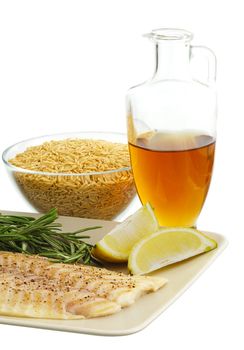 Mediterranean diet dinner ingredients including fresh fish, brown rice, herbs, lemon and olive oil