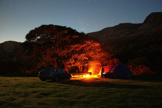 Tentside camping fire under the night sky