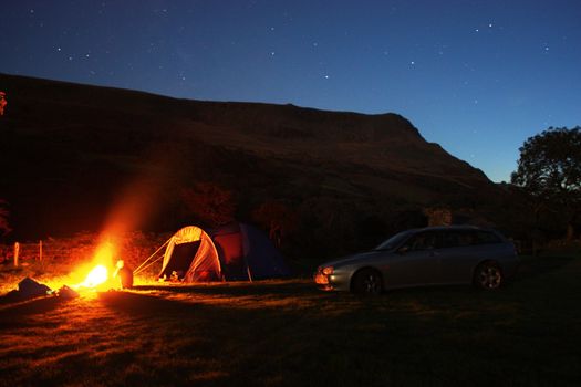 Tentside camping fire under the night sky