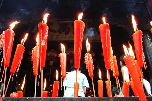 Joss sticks and red candles burning at a Chinese temple