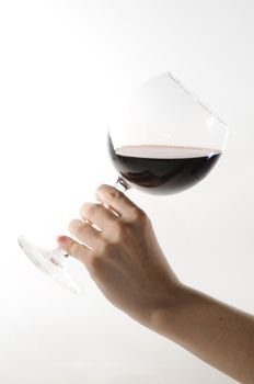 Red wine goblet glass held by female hand