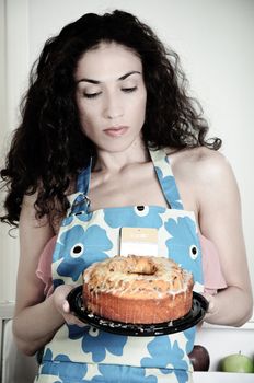 Beautiful woman baking cakes and cookies in a white home kitchen oven