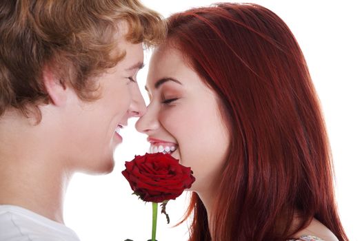 Young caucasian couple holding red rose over white background.