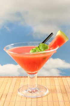 a glass of melon smoothie with fresh lemon balm