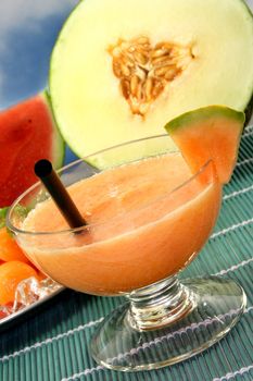 a glass of cucumber melon smoothie with fresh lemon balm