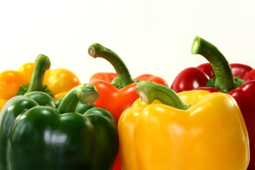 five colorful bell peppers on a white background