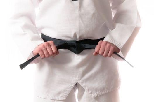 Man in martial arts uniform holding his black belt with both hands