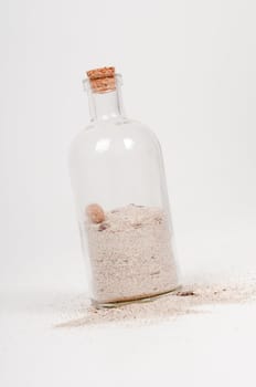 Shot of bottle with sand on light background