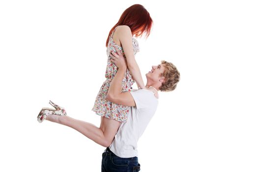 Handsome caucasian boy lifiting up his girlfriend, isolated on white background.