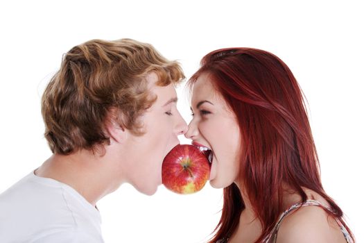 Young caucasian couple biting red apple over white background.