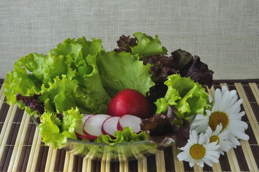 Vegetables on a glass plate and flowers
