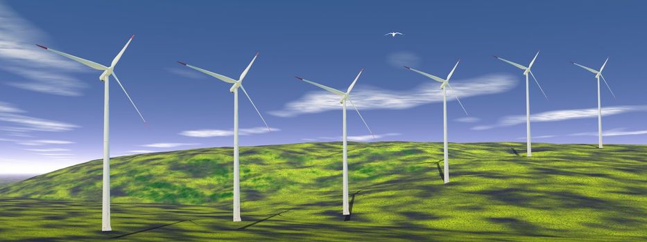 Bird flying upon wind turbines on a green hill with blue sky
