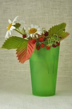 Bouquet from red berries and colours in a green vase

