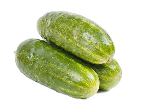 Three fresh green cucumbers over white background
