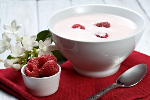 some fresh seasonal summer raspberries with yogurt