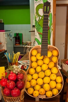 Fresh juicy oranges inside an old guitar at a market display