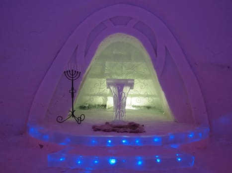 Illuminated chapel in an ice hotel in lapland in the evening.