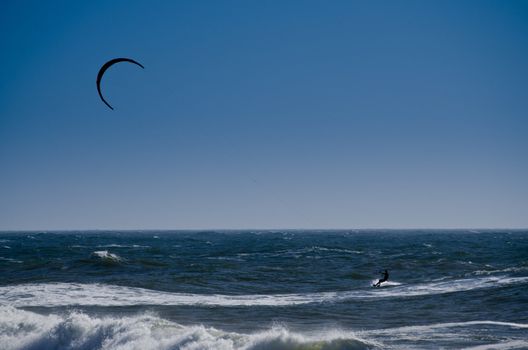 Silhouette of a kite surfer on the ocean.