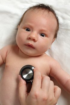 Photo of a doctor checking a baby's heartbeat with a stethoscope.