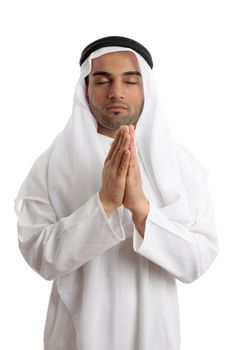 Man wearing middle easter attire with hands together in quiet prayer.