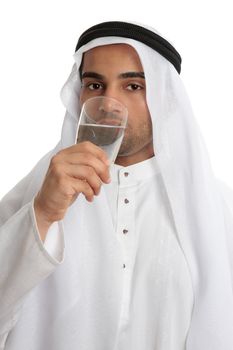 An arab middle eastern man wearing traditional clothing, is drinking a tall glass of clean fresh water. Water shortage stress from an increasing arab population and climate change compounding the problem has put pressure on providing safe clean fresh water to all in the arab regions.