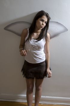 young girl with butterfly wing pulling on her necklace with expression of questionnement