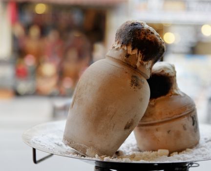 Turkish national dish of clay oven baked meat or vegetarian dish sealed with dough on display to tempt in a restaurant window. Landscape, copy space and crop space
