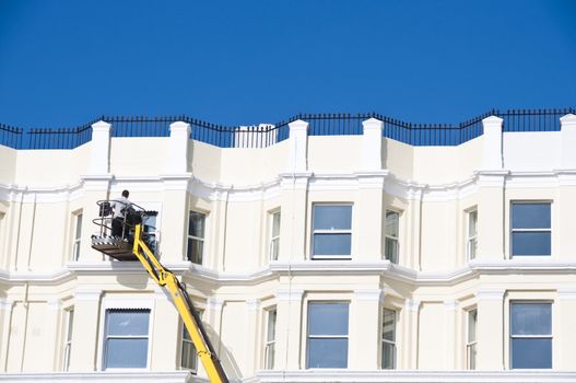 A man cleaning sash windows from outside in the UK