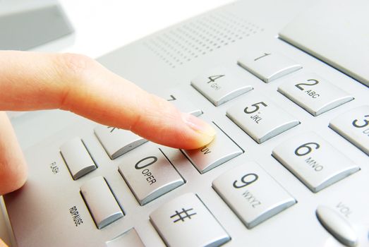 finger with  gray telephone keypad
