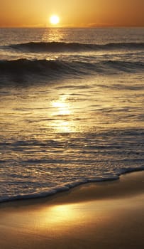 a picture of the sun falling on sand and water