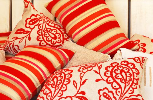 a Collection of funky pillows in different fabrics.