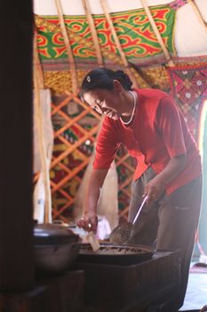 Mongolian woman prepare bread  inside the nomads tent