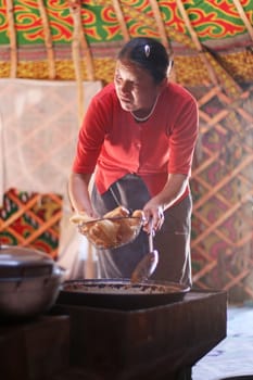 Mongolian woman prepare bread  inside the nomads tent