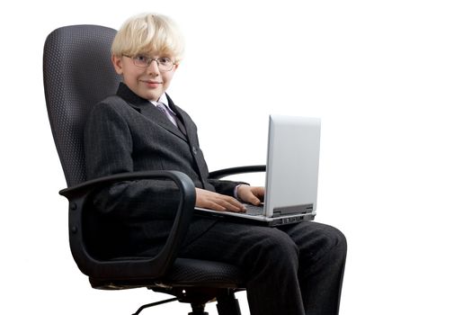 Smiling young boy sitting with the laptop