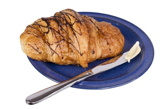 knife and croissant with chocolate on blue dish