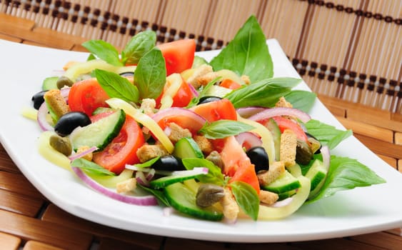 Fresh vegetable salad with basil, capers, olives, marinated with croutons