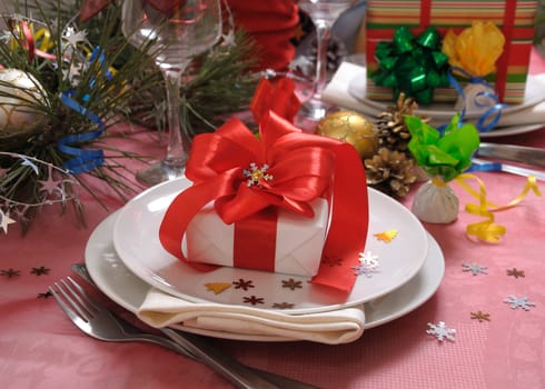 Gift with red bow on a festive table for Christmas