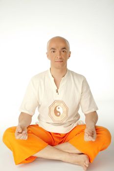Man sitting in lotus position looking at camera, isolated on white